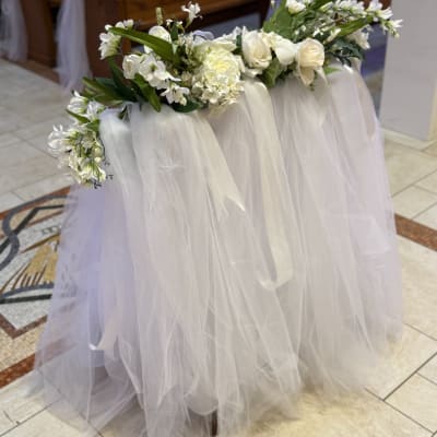 White floral garland draped over a tulle-covered table