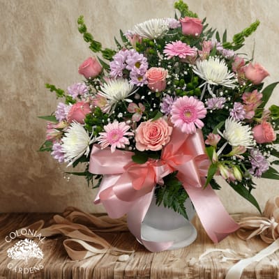 Pink and white mixed bouquet in a white vase with a satin ribbon