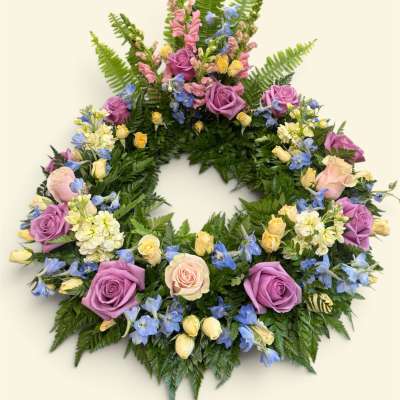 Circular floral wreath with purple and pink roses and blue flowers