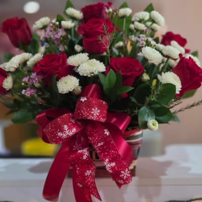Bouquet of red roses and white button flowers with a red ribbon bow