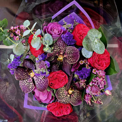 Bouquet of red roses, purple orchids, and pink cabbage roses