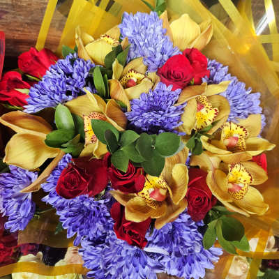 Bouquet of red roses, purple chrysanthemums, and yellow orchids
