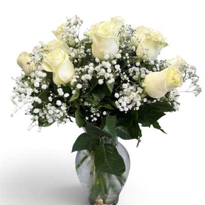White roses and baby's breath in a clear glass vase