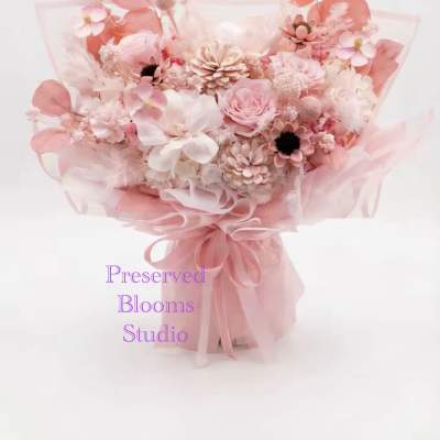 Pink preserved flower bouquet wrapped in sheer pink paper