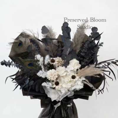 Dark bouquet with white flowers, peacock feathers, and black foliage