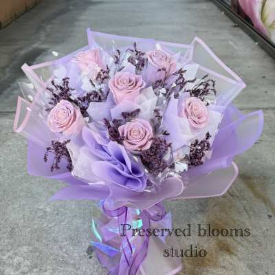 Bouquet of pale pink roses wrapped in lavender paper