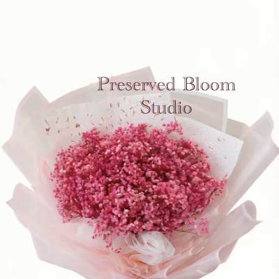 Pink preserved flower bouquet wrapped in pale pink paper