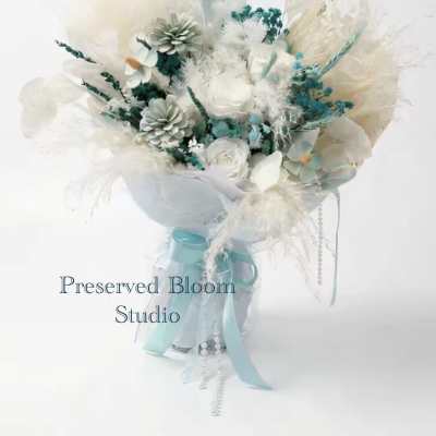 White and pale blue bouquet with ribbon and decorative accents