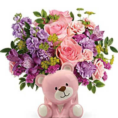 Pink and purple flower arrangement in a pink bear-shaped ceramic vase