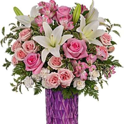 Tall bouquet of pink roses and white lilies in a faceted purple glass vase
