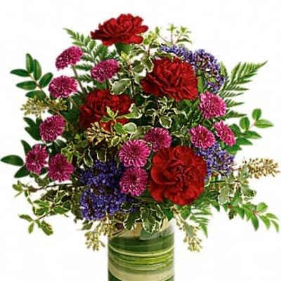 Medium mixed bouquet of red and purple flowers in a clear glass vase with green bands.