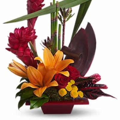 Tropical arrangement with orange lilies, red roses, and red ginger in a low red vase