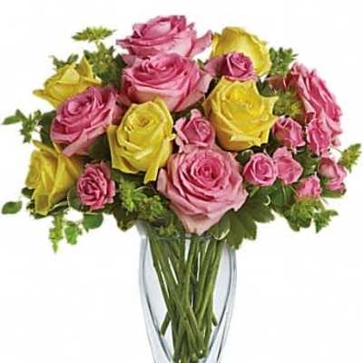 Arrangement of pink and yellow roses in a clear glass vase