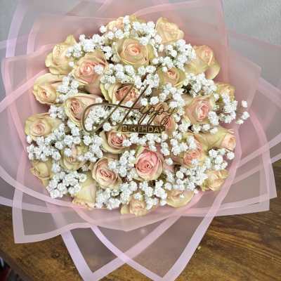 Bouquet of pale pink roses with white baby's breath and a birthday topper