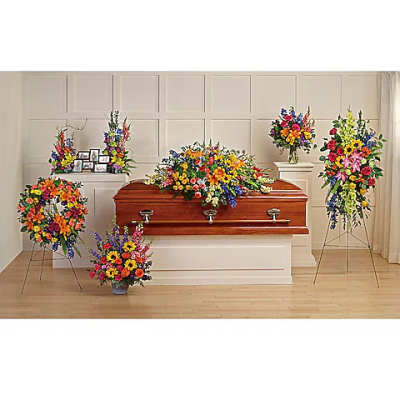 Funeral casket surrounded by colorful floral sprays and arrangements