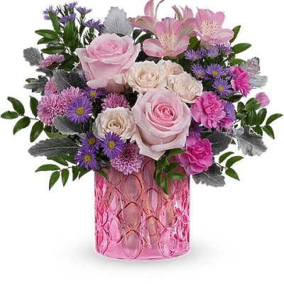 Pink and purple mixed flower arrangement in a pink glass vase
