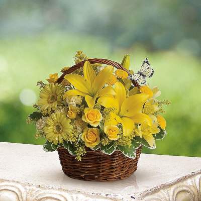 Yellow flowers arranged in a wicker basket with a butterfly decoration