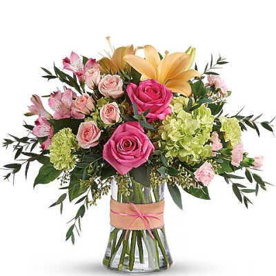Mixed bouquet of pink and yellow flowers in a glass vase