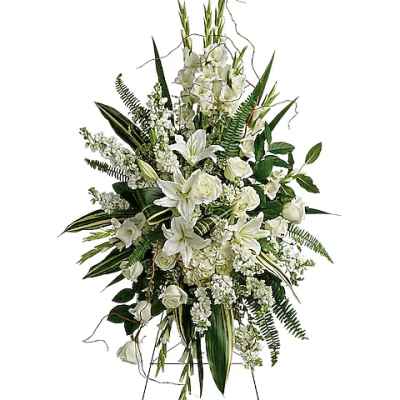 White floral standing spray on an easel with lilies and roses