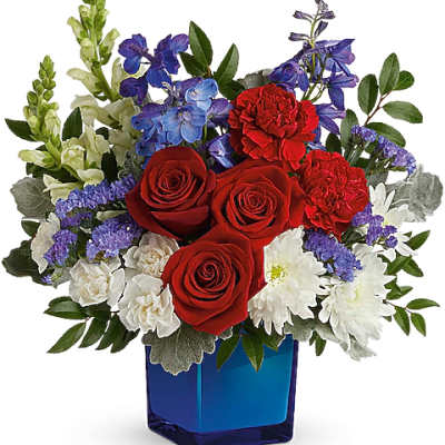 Red roses, white daisies, and purple flowers in a blue vase