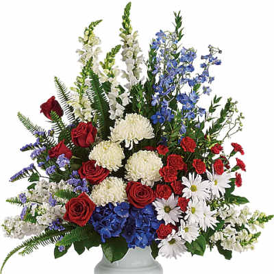 Red, white, and blue floral arrangement in a white vase