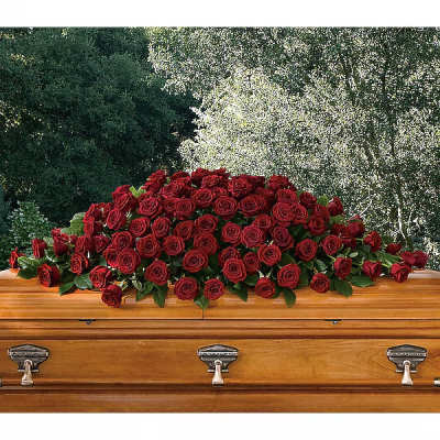 Red rose casket spray on a wooden coffin