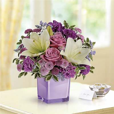 Purple and pink bouquet with white lilies in a lavender vase