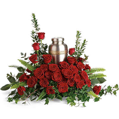 Red roses arranged around a silver urn with greenery