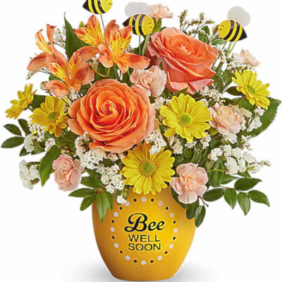 Bouquet of orange and yellow flowers in a bee-themed vase