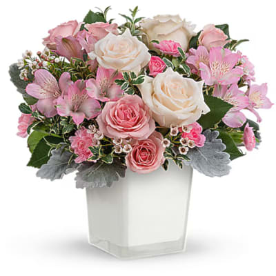 Pink and white rose bouquet in a clear square vase
