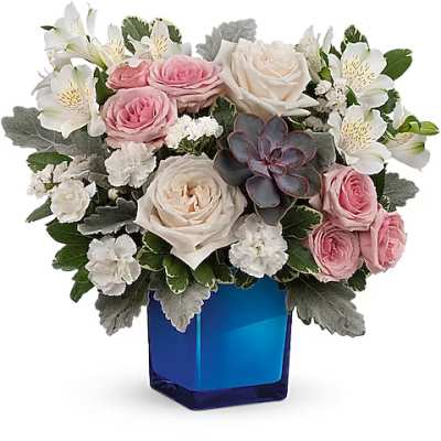 Pink and white roses with white alstroemeria in a blue glass vase