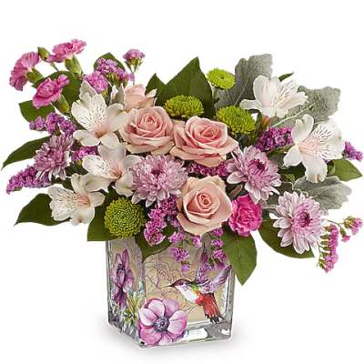 Pink roses and mixed blooms arranged in a decorated glass vase