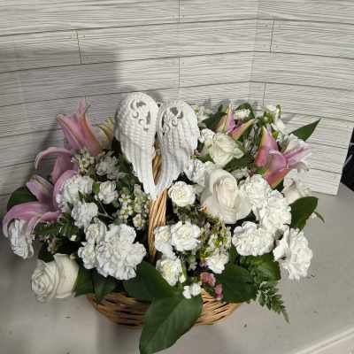 Basket arrangement of white roses, carnations, and pink lilies with angel wings