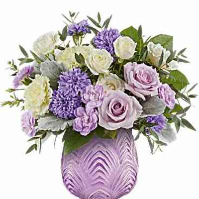 Lavender and white bouquet in a purple glass vase
