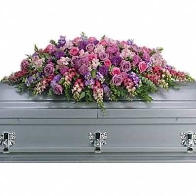 Pink and purple floral casket spray on a gray casket