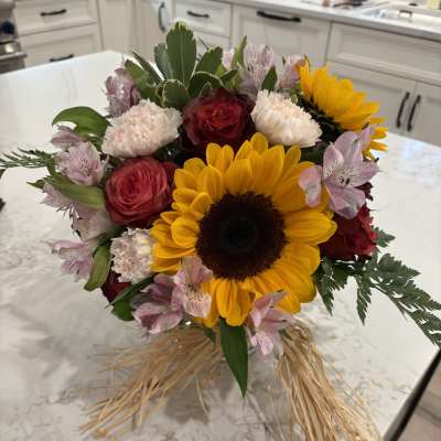 Bouquet with sunflowers, red roses, pink alstroemeria, and carnations