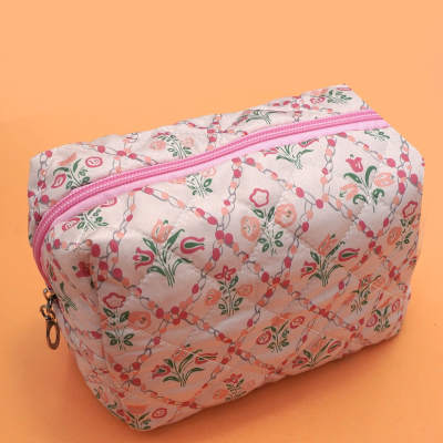 Quilted floral zip pouch on an orange background