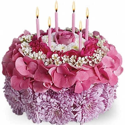 Pink floral cake with lit candles