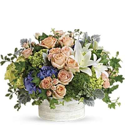 Peach roses and white lilies in a round white container