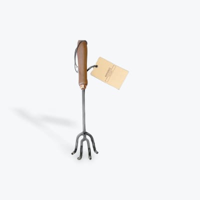 Handheld metal garden cultivator with a wooden handle and tag