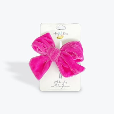 Bright pink velvet bow on a white display card