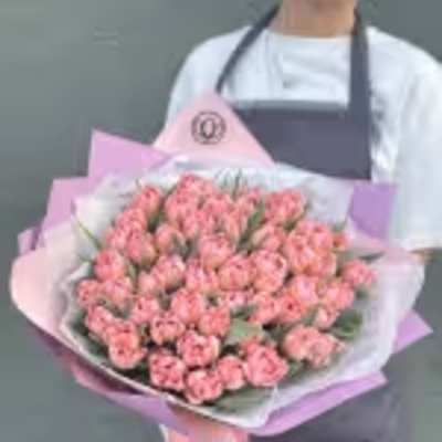 Large bouquet of pink carnations wrapped in pastel paper