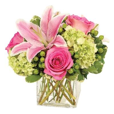 Pink lilies and roses arranged in a clear glass vase