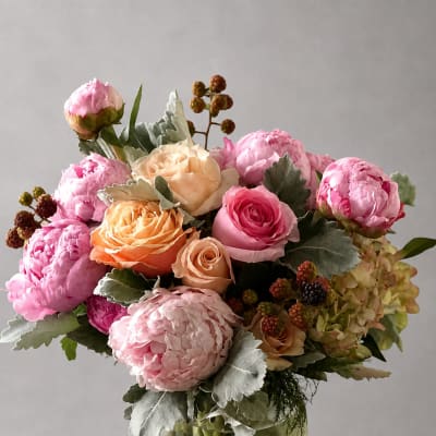 Pink and peach roses arranged in a clear glass vase