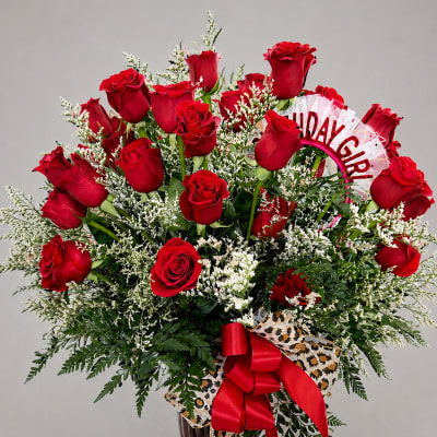 Bouquet of red roses in a glass vase with a red ribbon
