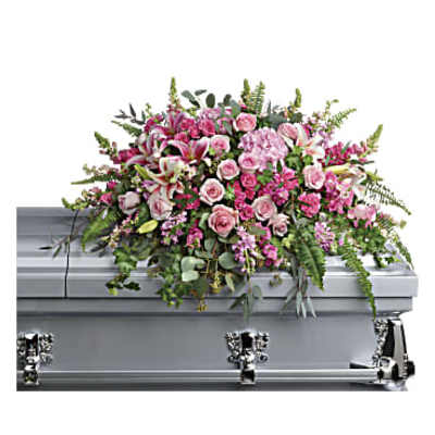 Pink and white floral casket spray on a silver casket