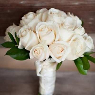 White rose bridal bouquet with green leaves and a wrapped handle