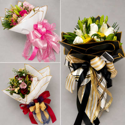 Three wrapped bouquets with lilies and mixed flowers, each tied with large decorative ribbons