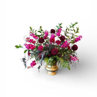 Pink and burgundy floral arrangement in a gold vase