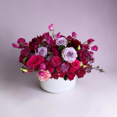 Pink and lavender rose bouquet in a white ribbed vase
